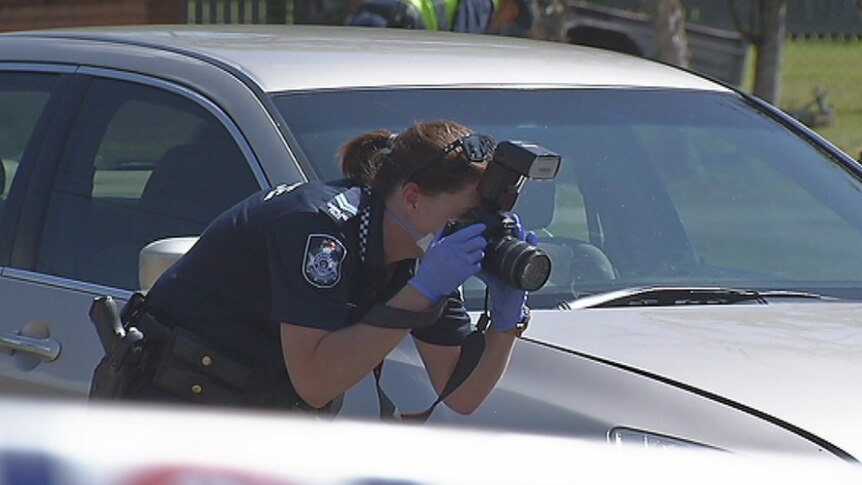A police officer photographs the crime scene