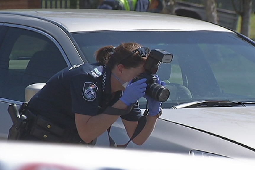 A police officer photographs the crime scene