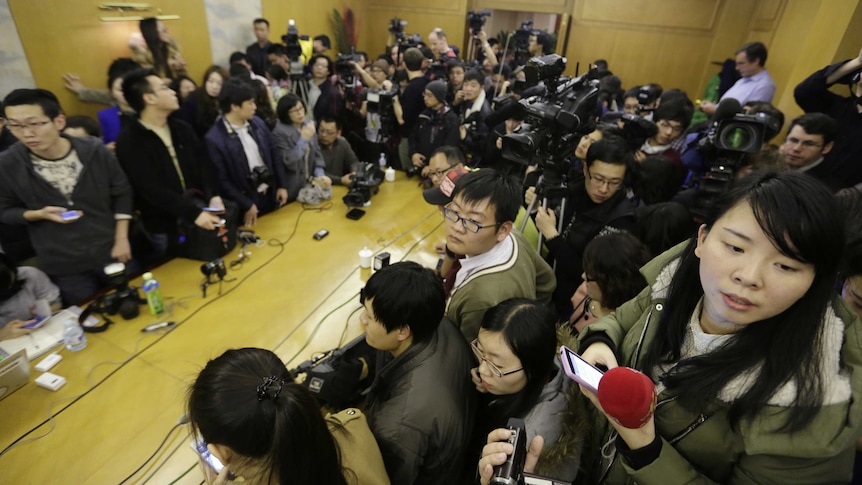Journalists in a crowded conference room at a Beijing hotel