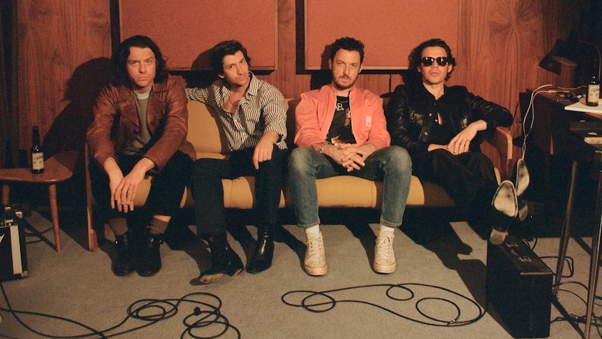 Arctic Monkeys sitting on a couch in a rehearsal space