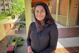 Soumi Gopalakrishnan smiles as she stands on a verandah of a building on ANU campus.