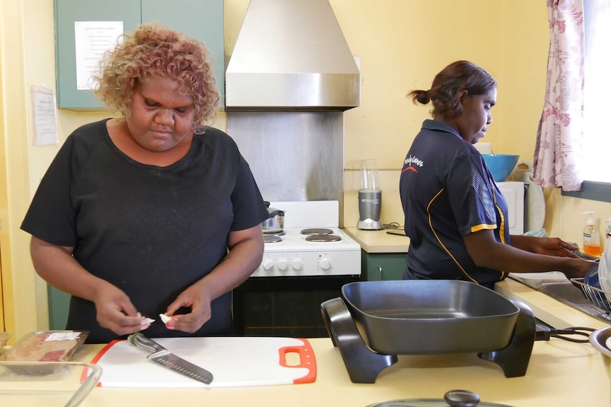 Two women prepare dinner at a women's centre in Balgo.