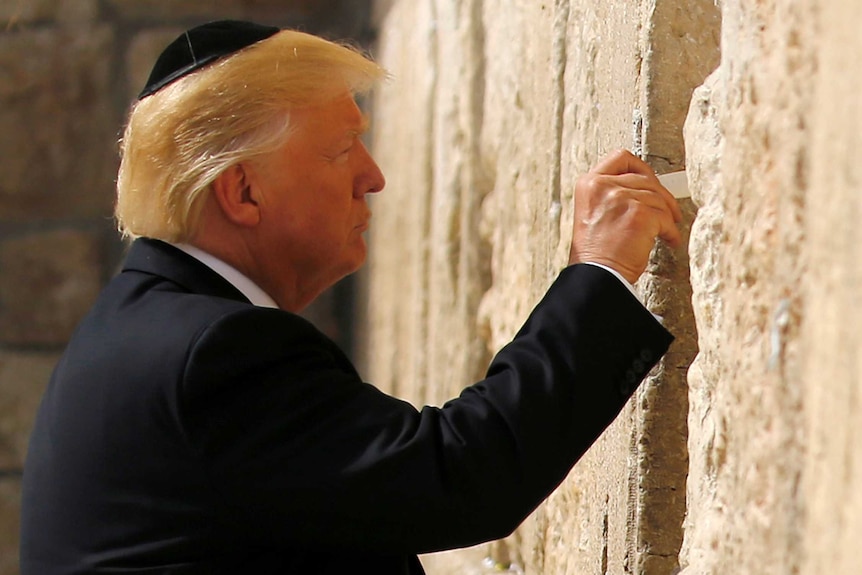 President Donald Trump prepares to leave a note at the Western Wall.