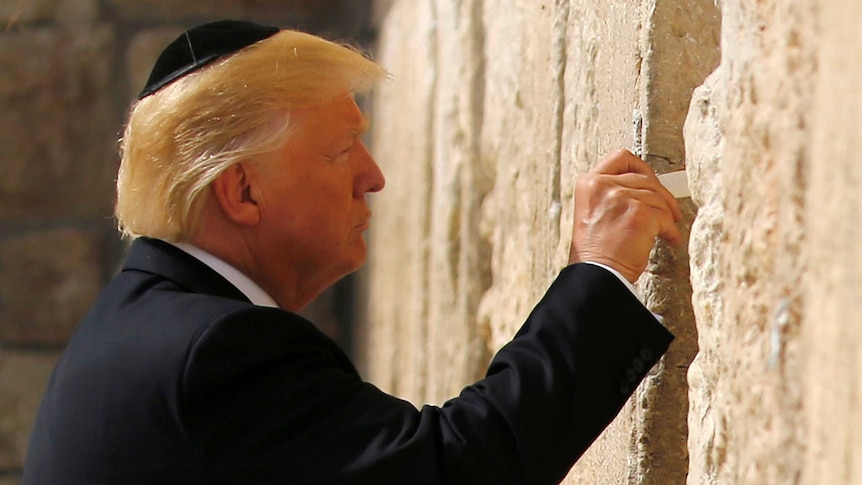 President Donald Trump prepares to leave a note at the Western Wall.