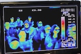 A thermal camera monitor shows the body temperature of passengers arriving at an airport.