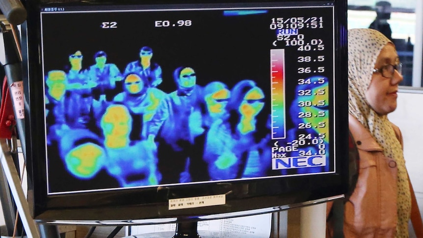 A thermal camera monitor shows the body temperature of passengers arriving at an airport.