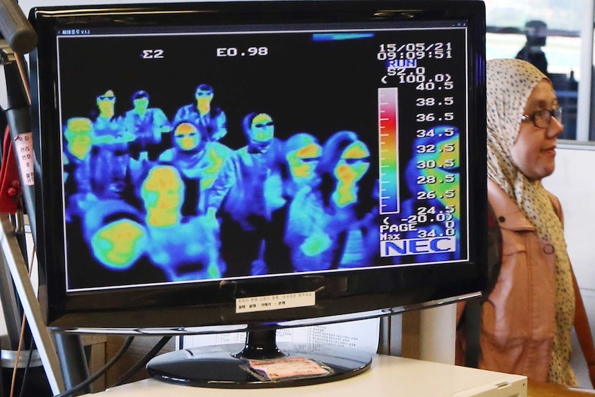 A thermal camera monitor shows the body temperature of passengers arriving at an airport.