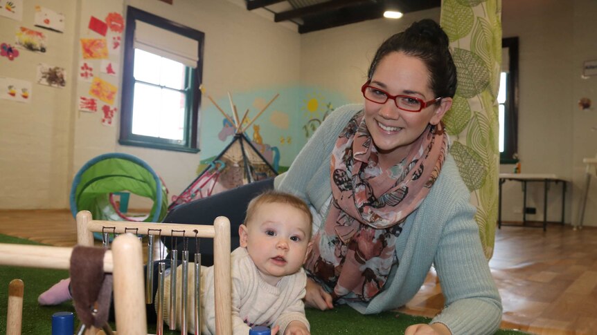 Louise takes time away from her desk to visit 7-month-old Hazel in the upstairs crèche.