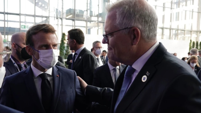 Prime Minister Scott Morrison lays his hand on the shoulder of French President Emmanuel Macron at the COP26 summit.
