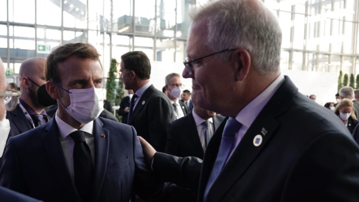 Prime Minister Scott Morrison puts his hand on French President Emmanuel Macron's shoulder at the COP26 summit.