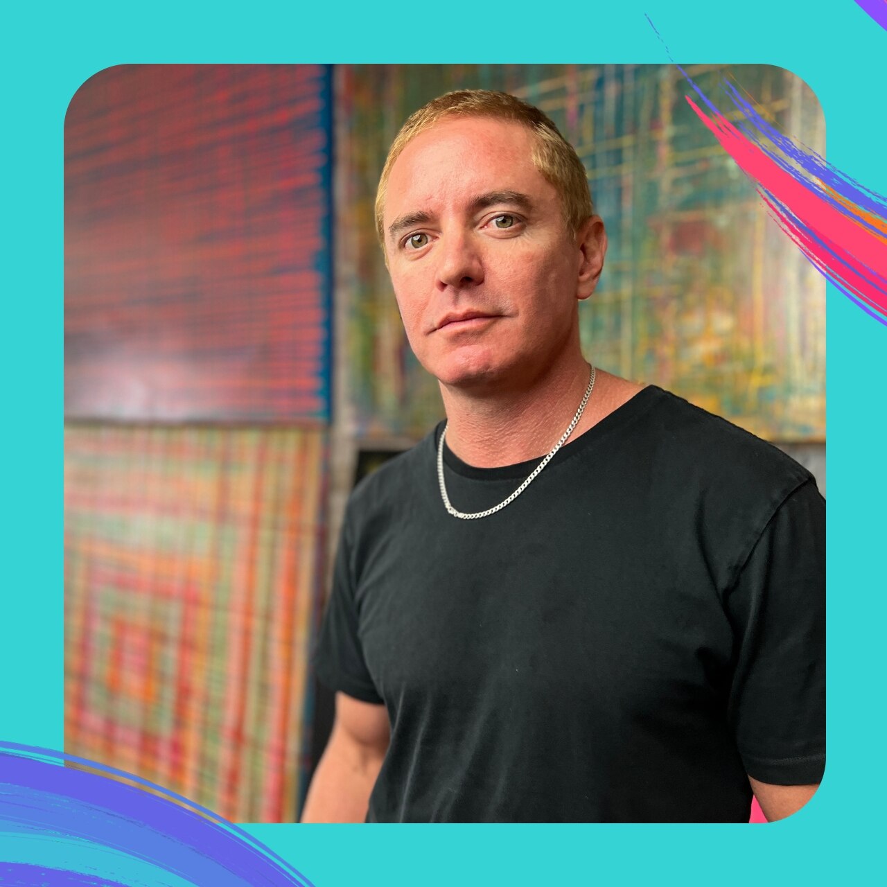 Artist Vincent Fantauzzo, with bleached cropped hair, stands in front of large paintings.