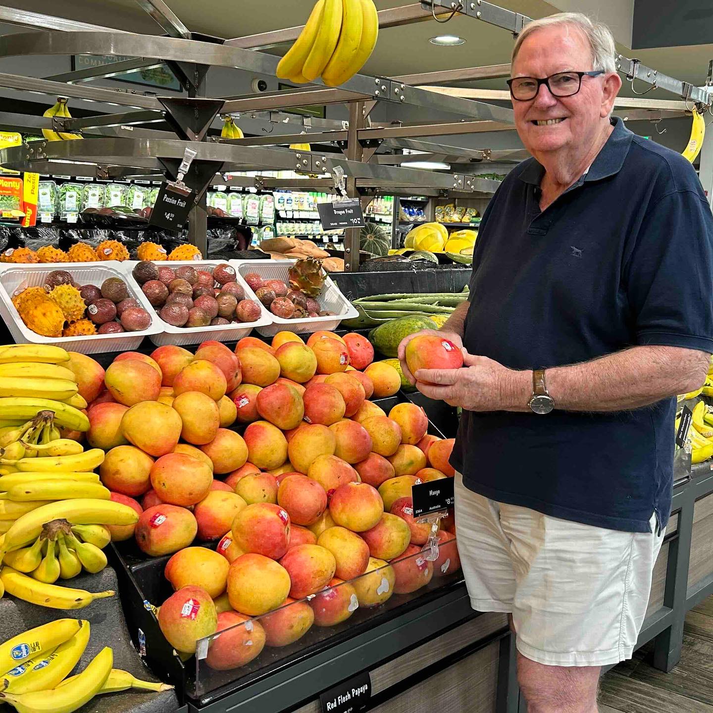 Scott Ledger holding a mango in a supermarket