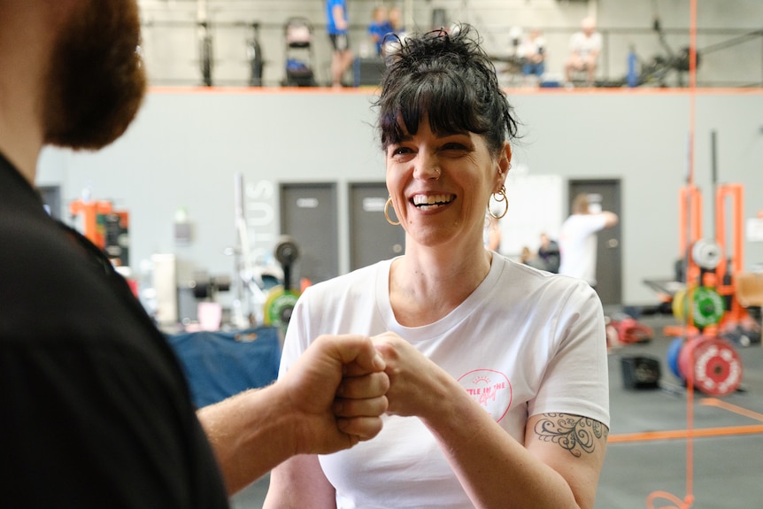 Justine Martin smiles and fist bumps a friend.