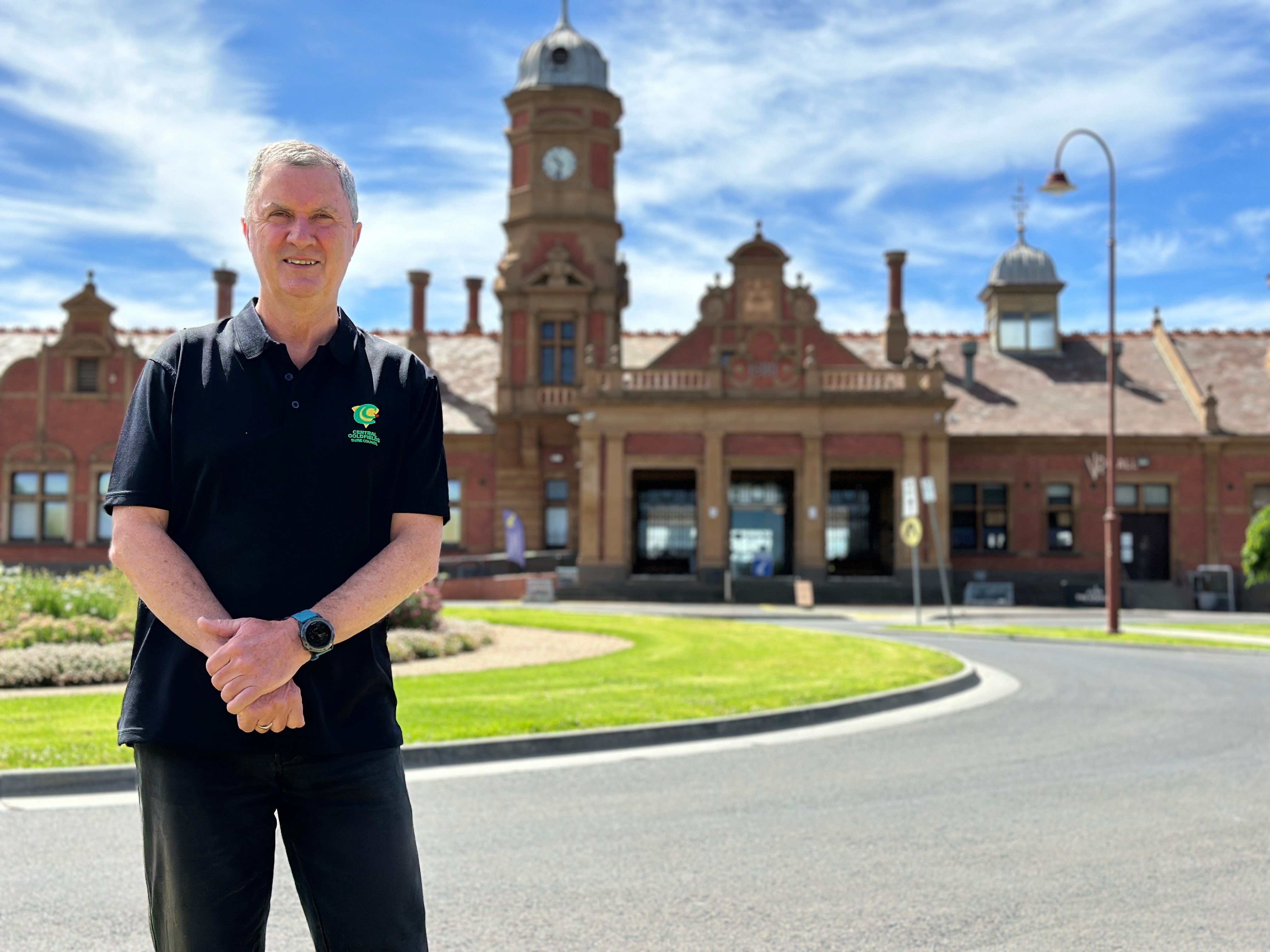 Um homem está em frente ao prédio da prefeitura.