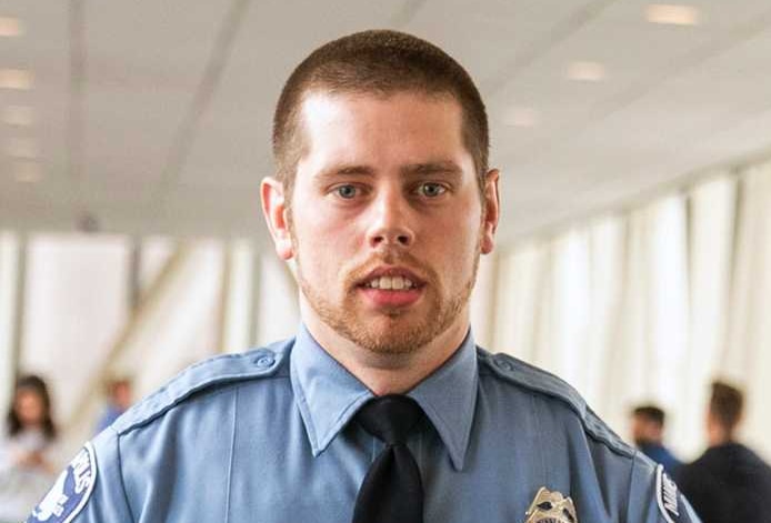 Minneapolis police officer Matthew Harrity walks down a hallway outside court with his lawyer and media cameramen.