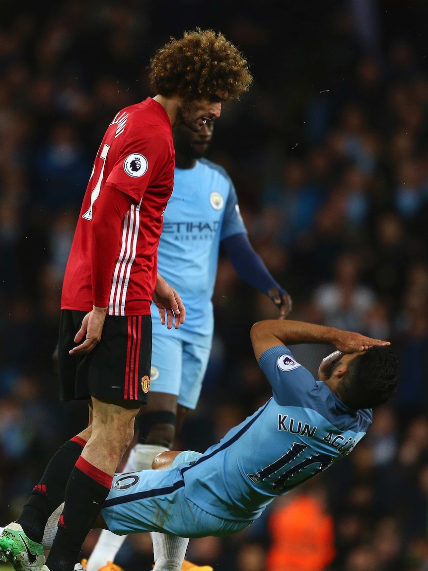 Sergio Aguero goes down after a headbutt from Fellaini