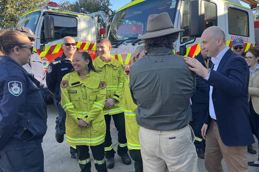 People standing around in emergency service outfits smiling 