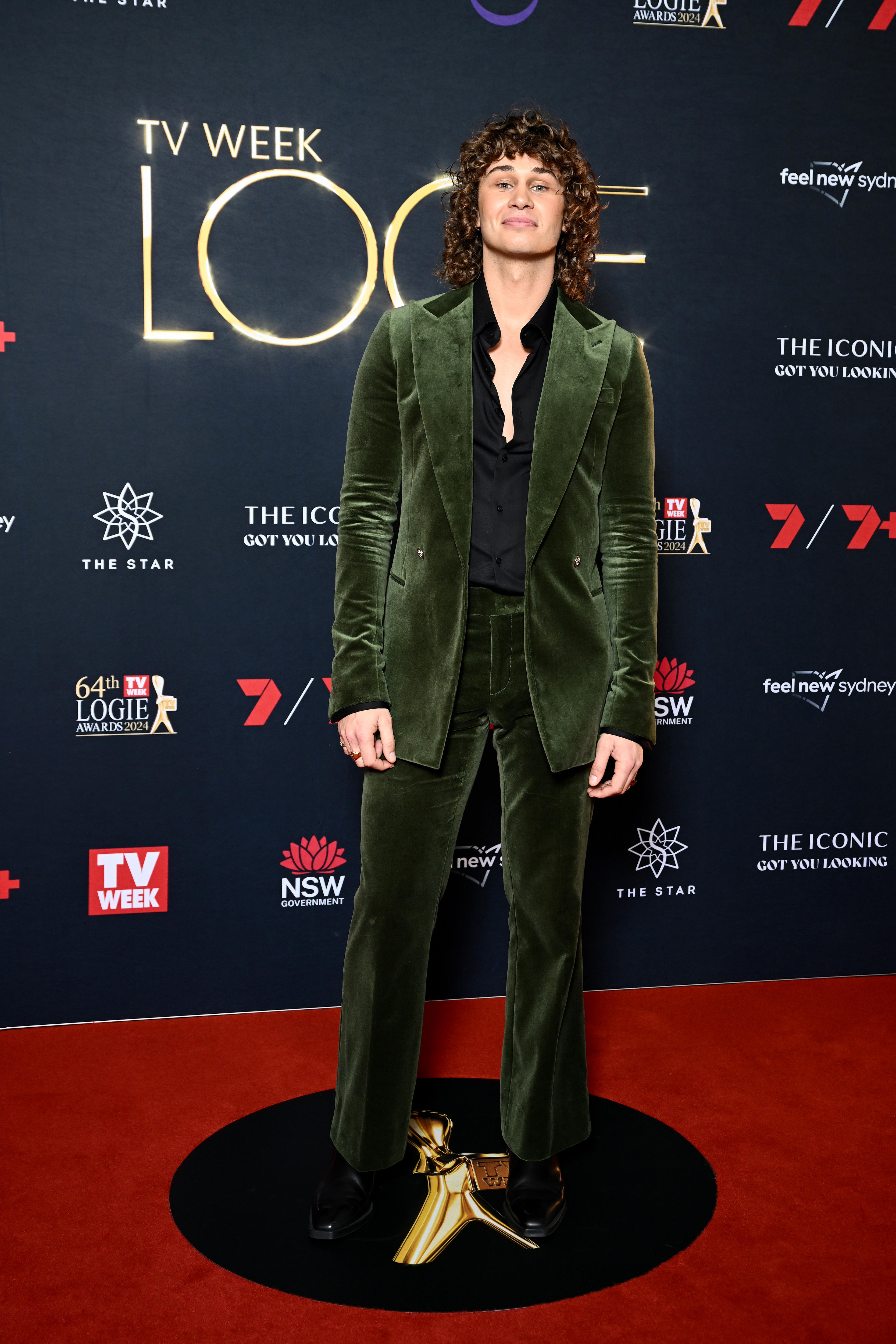 Matt Evans wears a velvet olive green suit