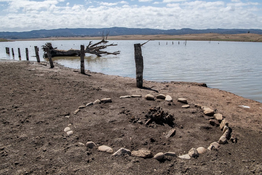 A circle of rocks can be seen in the dirt.