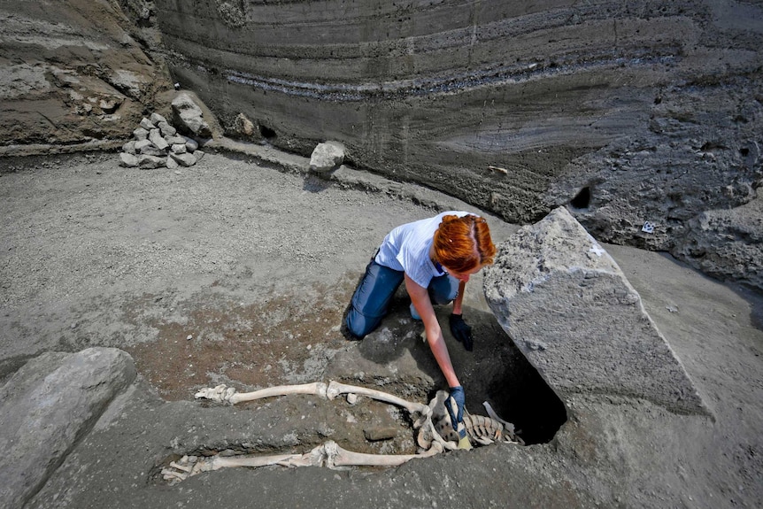 Anthropologist Valeria Amoretti works with a brush on a skeleton
