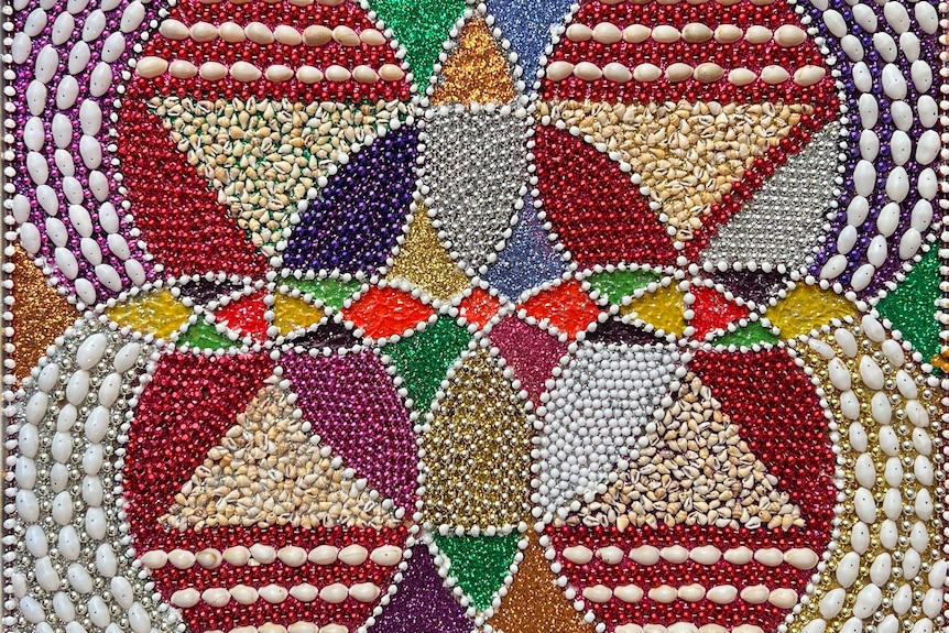 Close up of colourful artwork using beads and shells