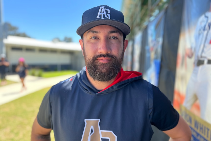 A baseball player with a cap and beard smiling