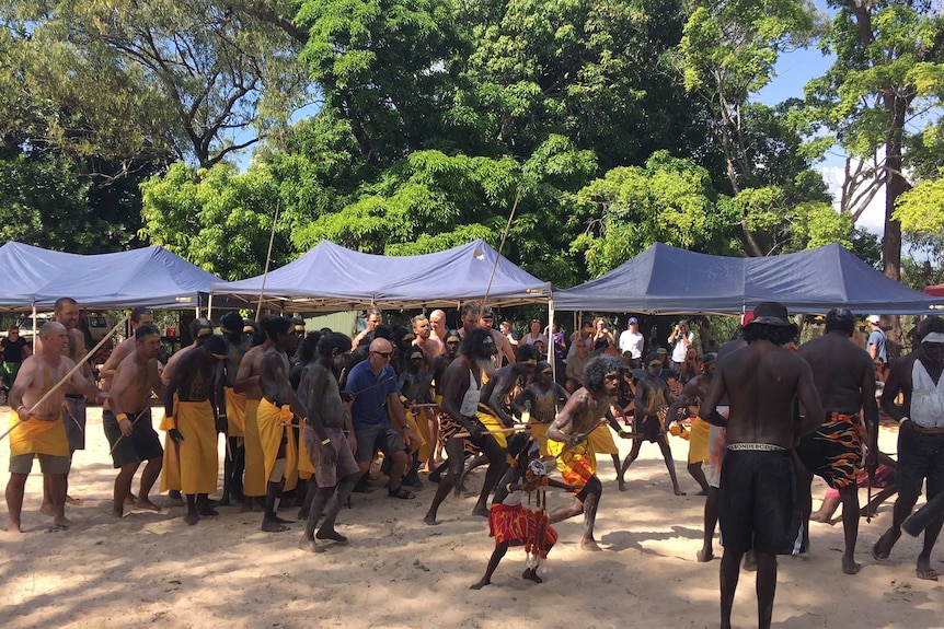 Paul Kelly participates in a traditional dance towards the memorial stone to Dr M Yunupingu.