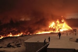 An aerial view of people watching as oil fields burn near Mosul.