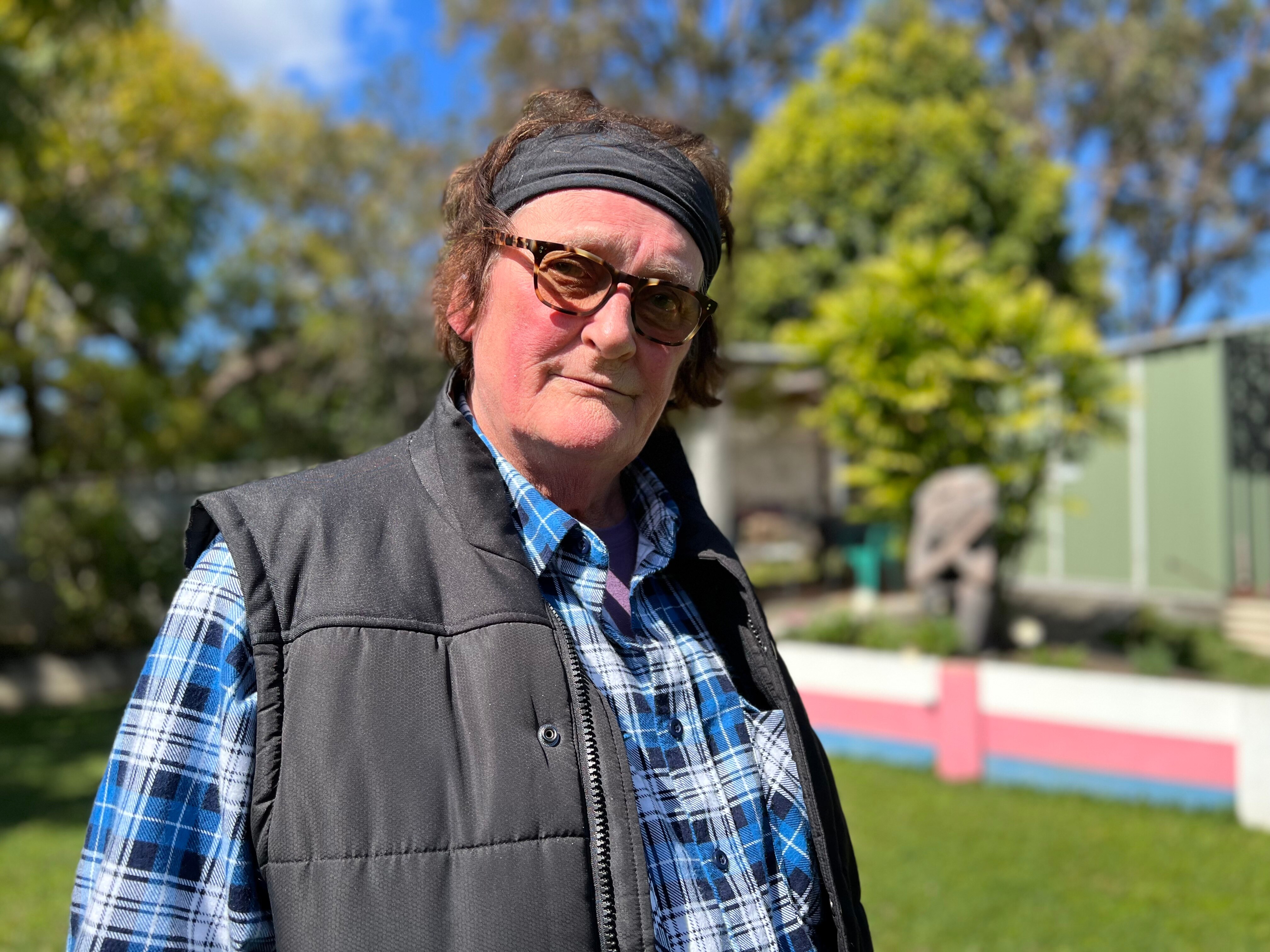 Gina Mather standing in her garden, looking at the camera