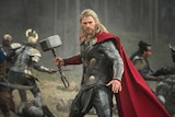 Man dressed as superhero holding a hammer 
