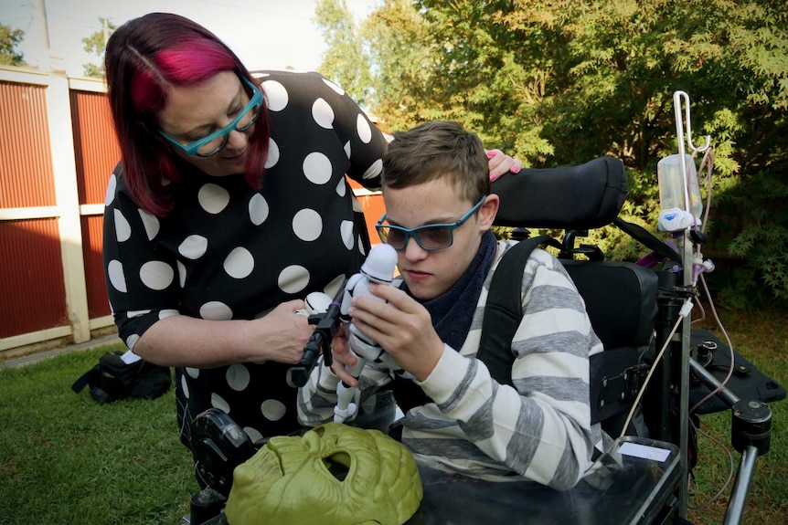 Margie Anderson leans down to chat to her son Elias, who is in a special-needs wheelchair.