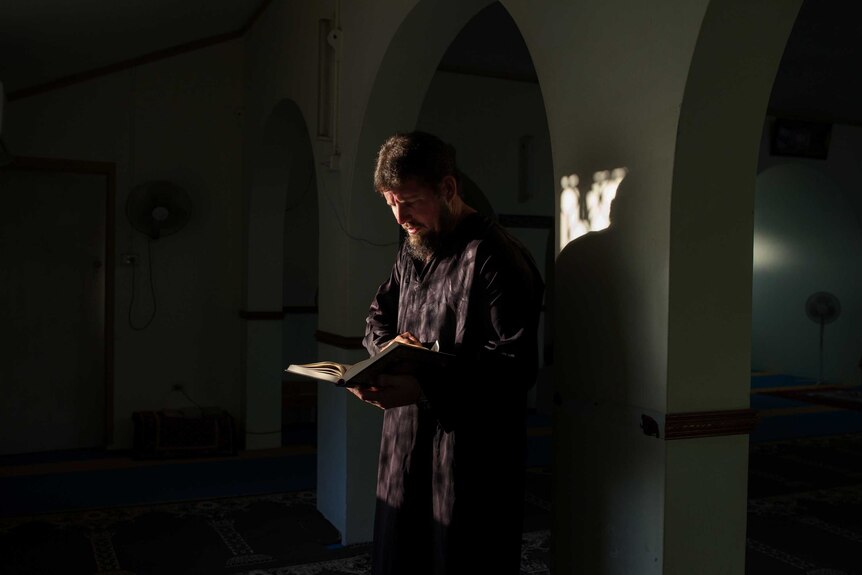 Christmas Island Islamic leader Greg McIntosh reads the Qu'ran.