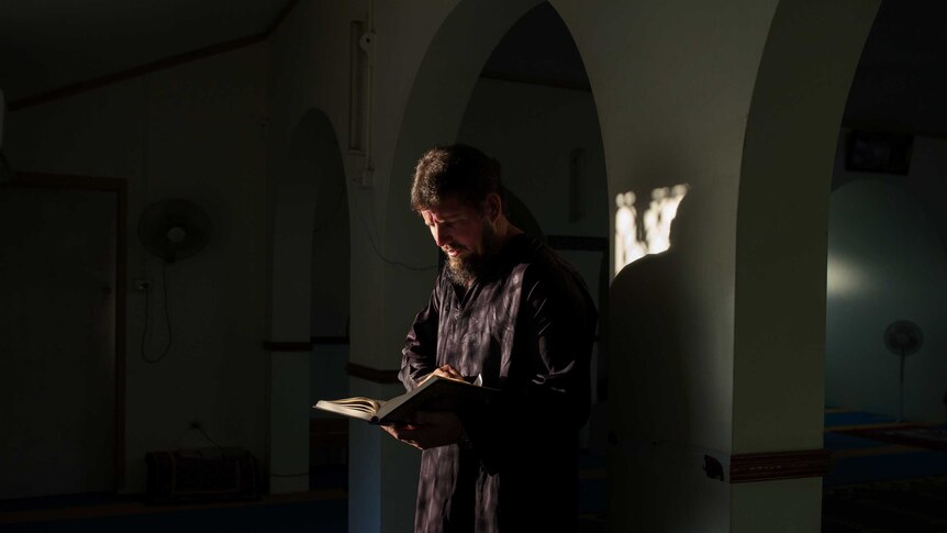 Christmas Island Islamic leader Greg McIntosh reads the Qu'ran.