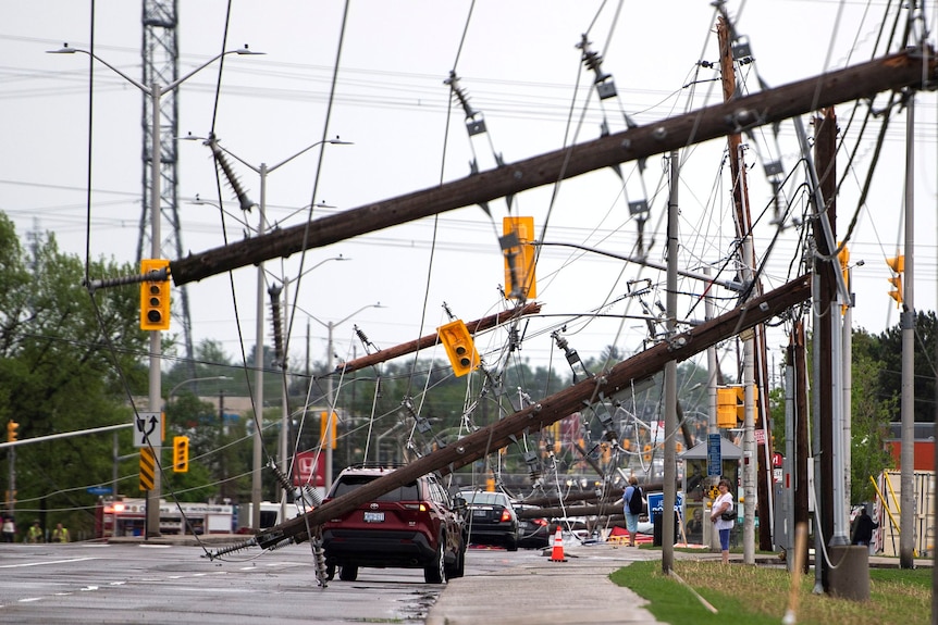 Cars driving through fallen powerlines across a road