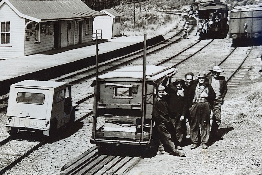 Old monochrome image of a gang of fettlers standing by their work trolley.