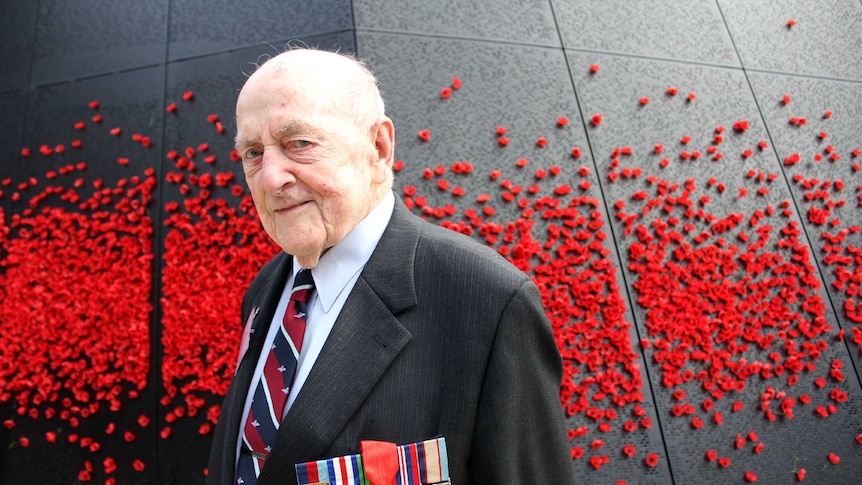 Lawrence Larmer stands at the Shrine of Remembrance wearing his new Legion of Honour Medal