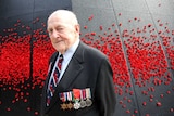 Lawrence Larmer stands at the Shrine of Remembrance wearing his new Legion of Honour Medal