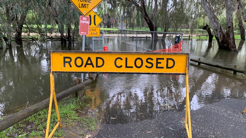 A road closed sign stands infront of floodwaters