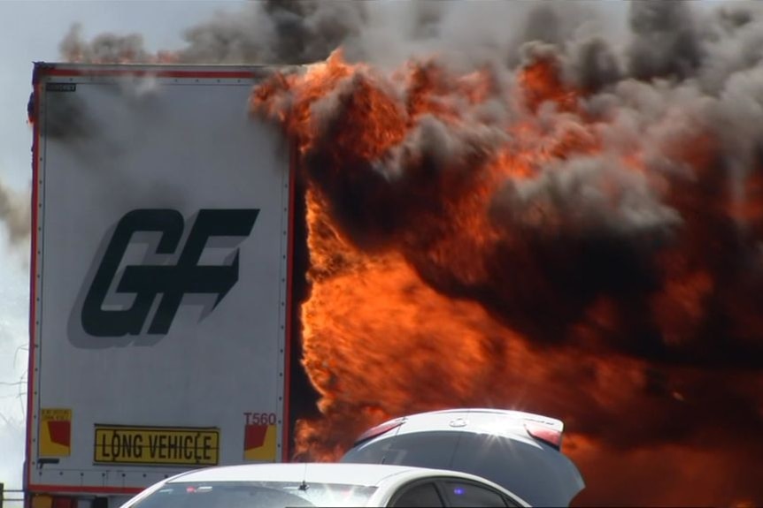 Black smoke billows from a fire consuming a trailer on the Eastern Freeway.