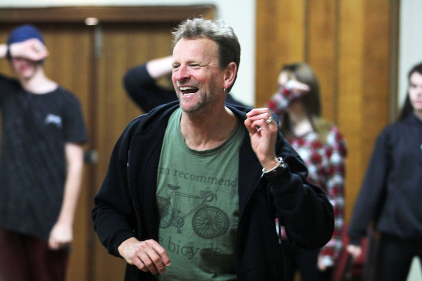 Man laughing with kids in the background