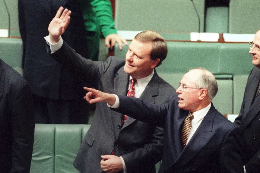 Five men in dark suits stand near the green front bench of the lower house