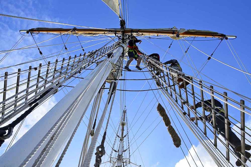 Crew members in the rigging of the tall ship One and All.