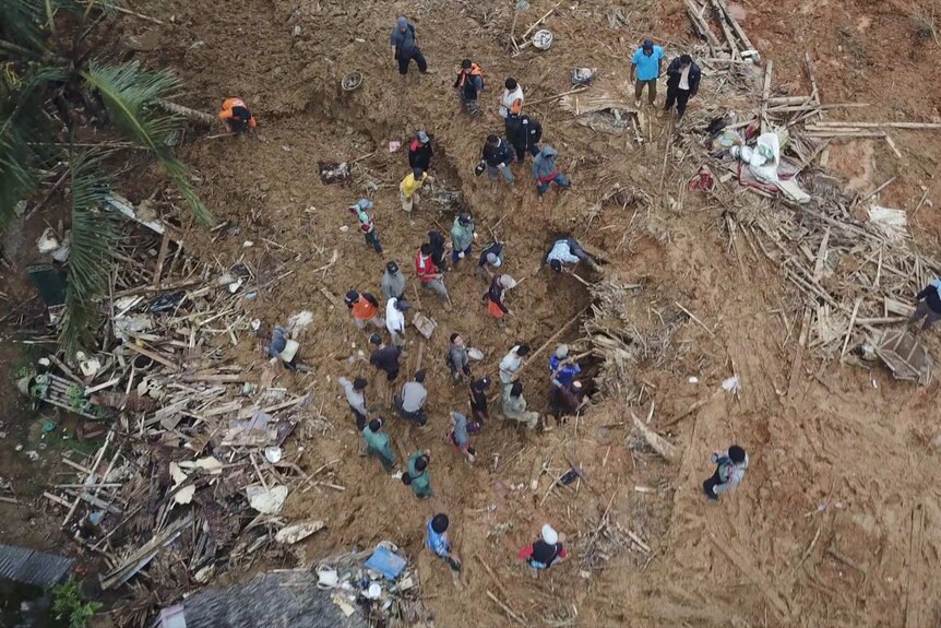 Locals dig for survivors and belongings in the thick mud