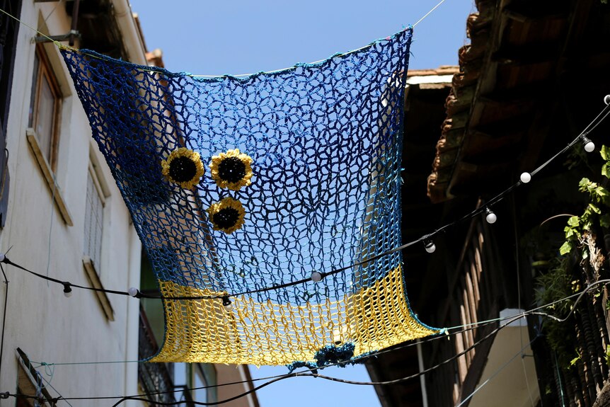 A Ukrainian-themed weaved canopy hangs between twp buildings. 
