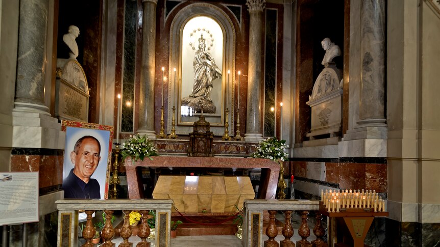 marble tomb, decorated, with white statues, portrait of pino puglisi on the left hand side