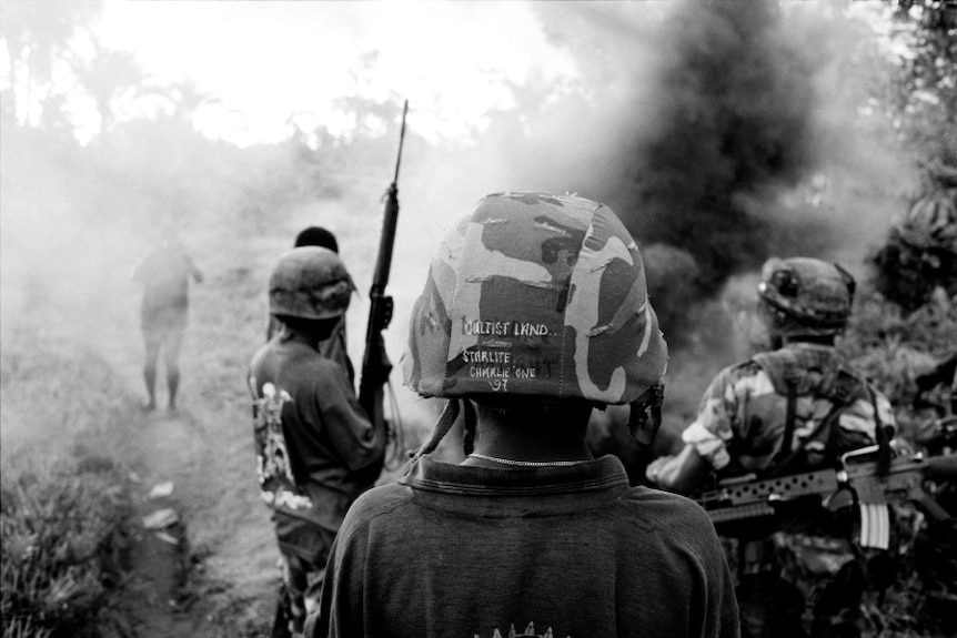 An old photo of soldiers in a jungle.