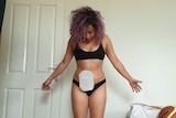 Dahlia Matkovic with her arms spread by her side, showing her ileostomy bag attached to her stomach