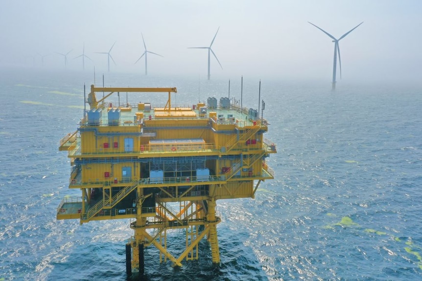 An offshore power plant with offshore wind turbines in the background