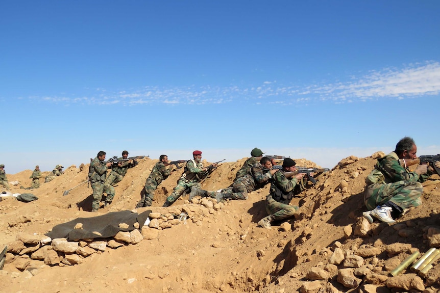 Syrian army soldiers take positions on the outskirts of Raqqa.