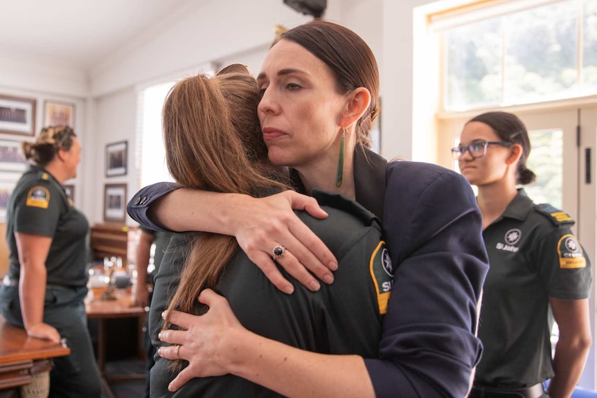 Jacinda Ardern hugging a woman wearing a search and rescue uniform.
